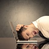 Frustrated businessman’s head on keyboard